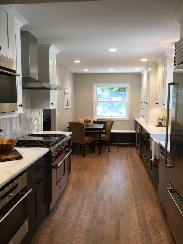 Inspiration for a small transitional galley medium tone wood floor and brown floor eat-in kitchen remodel in Chicago with a farmhouse sink, shaker cabinets, gray cabinets, quartzite countertops, gray backsplash, stone tile backsplash, stainless steel appliances, no island and white countertops