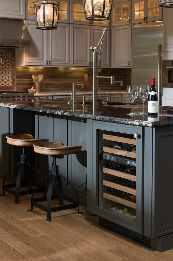 Inspiration for a huge transitional galley light wood floor kitchen remodel with raised-panel cabinets, gray cabinets, quartz countertops, multicolored backsplash, stone tile backsplash, stainless steel appliances and an island