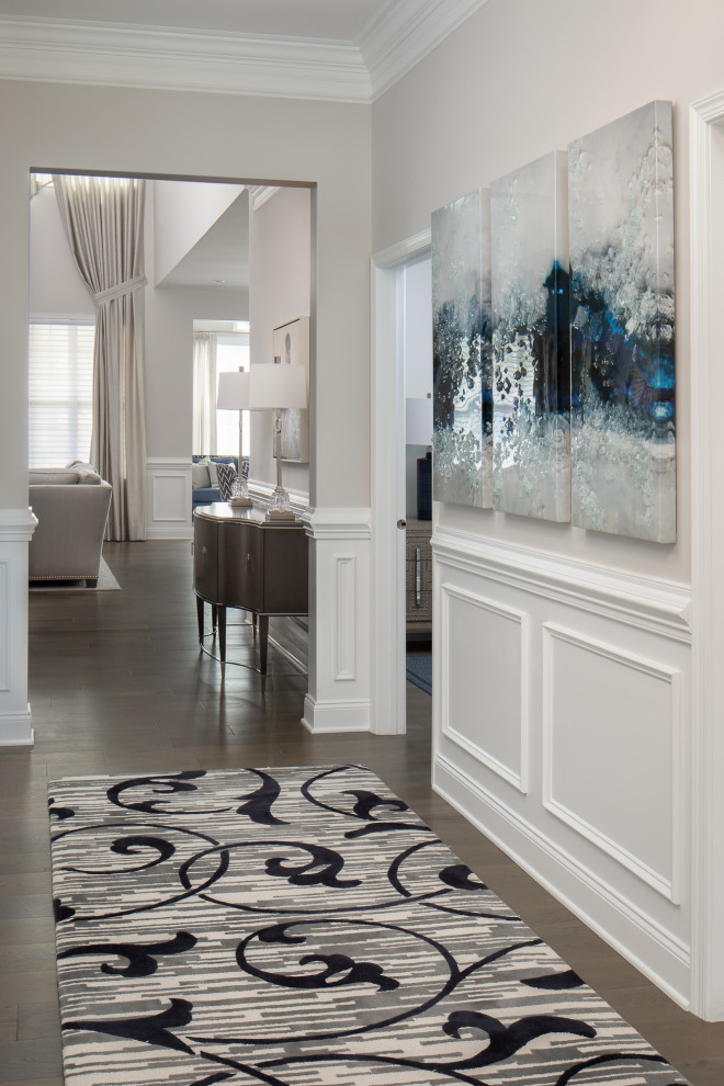 Example of a mid-sized classic medium tone wood floor, gray floor and wainscoting hallway design in Newark with gray walls