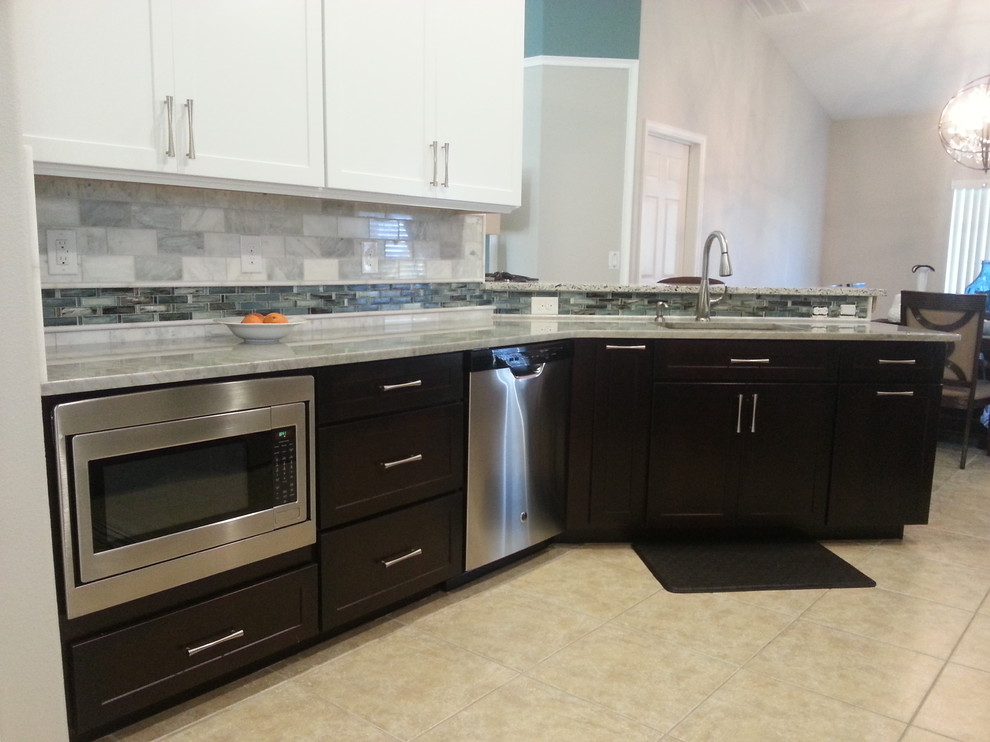 Small transitional galley ceramic tile eat-in kitchen photo in Orlando with shaker cabinets, white cabinets, quartzite countertops, gray backsplash, stone tile backsplash, stainless steel appliances and a peninsula