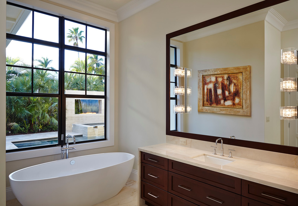 Inspiration for a mid-sized contemporary master bathroom in Miami with recessed-panel cabinets, dark wood cabinets, a freestanding tub, beige walls, an undermount sink and marble benchtops.