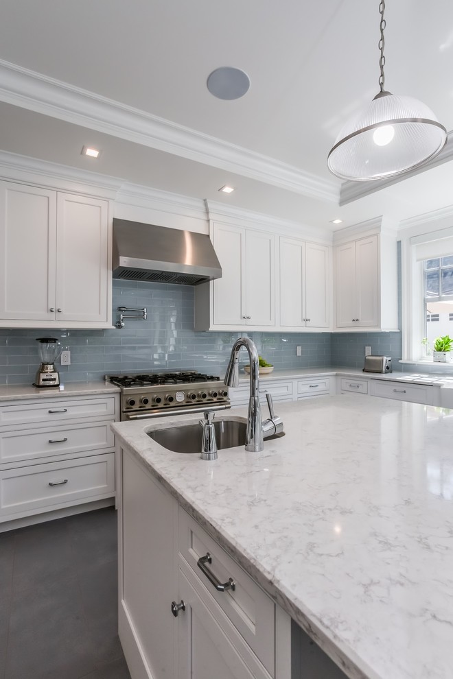 Design ideas for a mid-sized transitional eat-in kitchen in Atlanta with an undermount sink, shaker cabinets, white cabinets, quartzite benchtops, grey splashback, glass tile splashback, stainless steel appliances, with island, grey floor, white benchtop and ceramic floors.