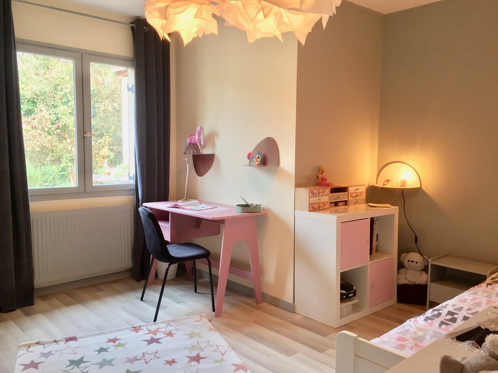 This is an example of a mid-sized midcentury kids' bedroom for kids 4-10 years old and girls in Other with grey walls, laminate floors and beige floor.