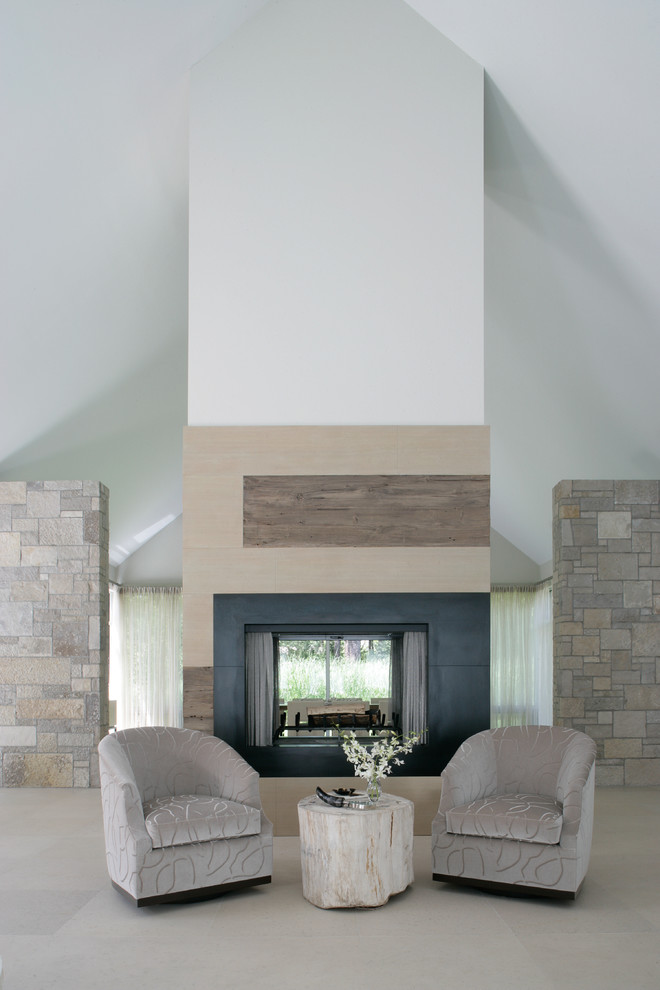 Mid-sized country formal loft-style living room in New York with grey walls, no tv, limestone floors and a two-sided fireplace.