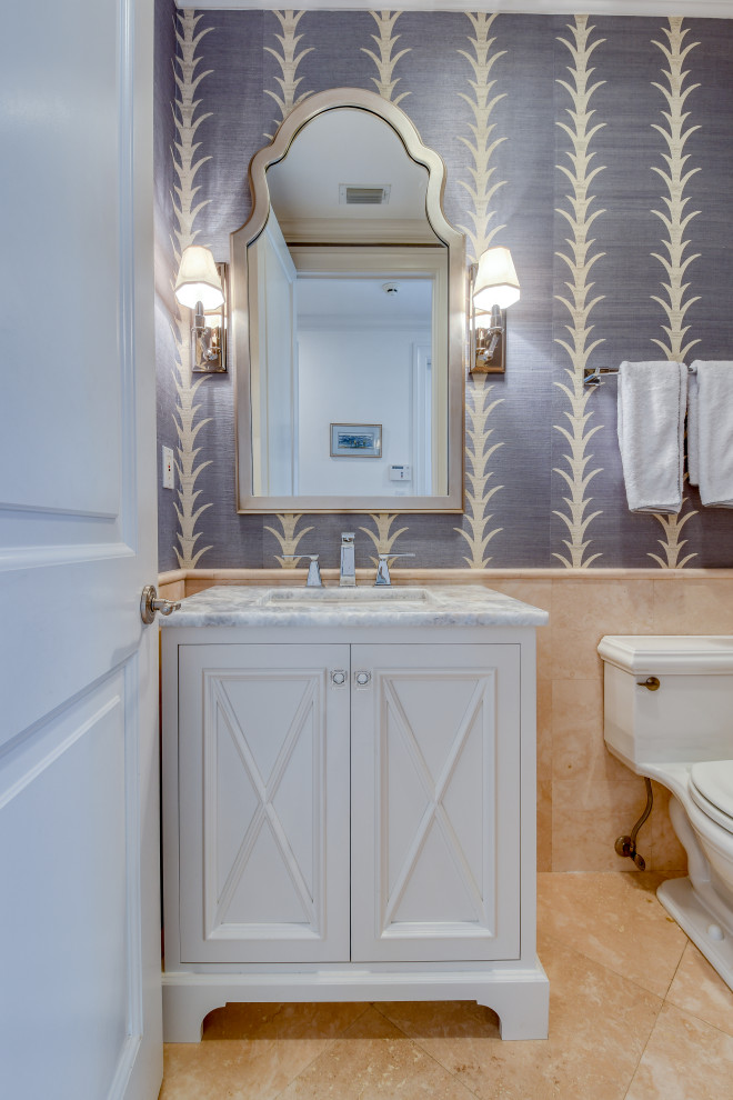 Coastal cloakroom in Other with recessed-panel cabinets, white cabinets, beige tiles, grey walls, a submerged sink, a freestanding vanity unit and wallpapered walls.
