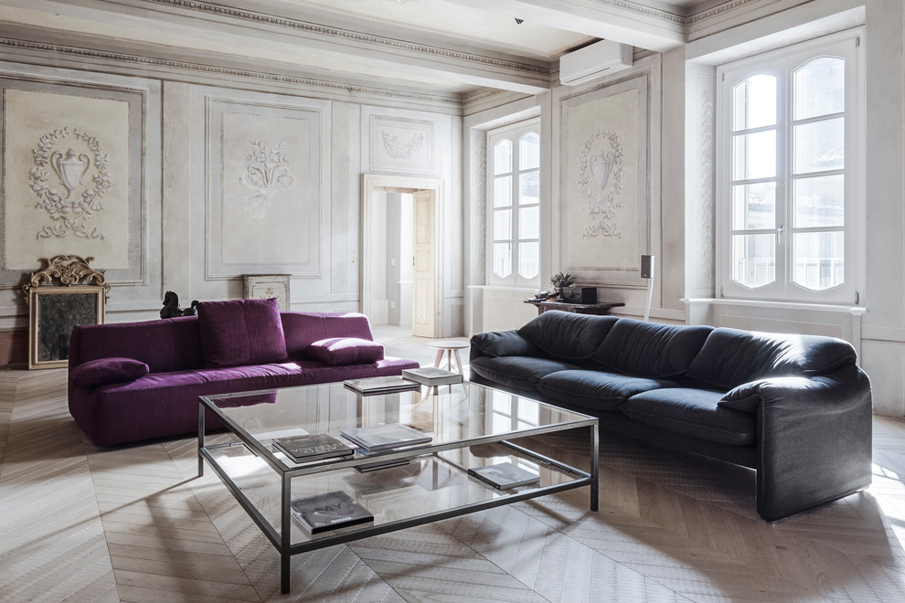 This is an example of a large contemporary living room in Milan with light hardwood floors.