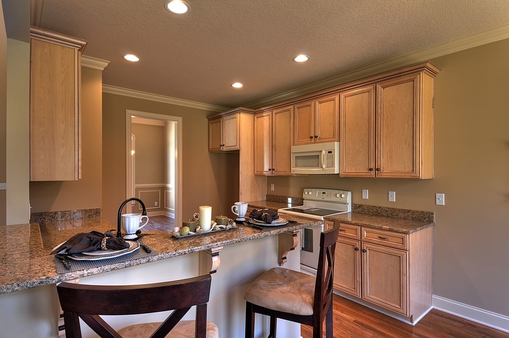 Inspiration for a transitional l-shaped eat-in kitchen remodel with an undermount sink, flat-panel cabinets, light wood cabinets, granite countertops and colored appliances