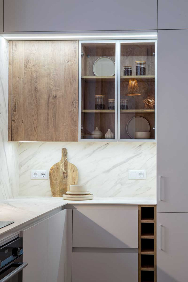 Cette photo montre une cuisine moderne avec un placard à porte plane et des portes de placard blanches.