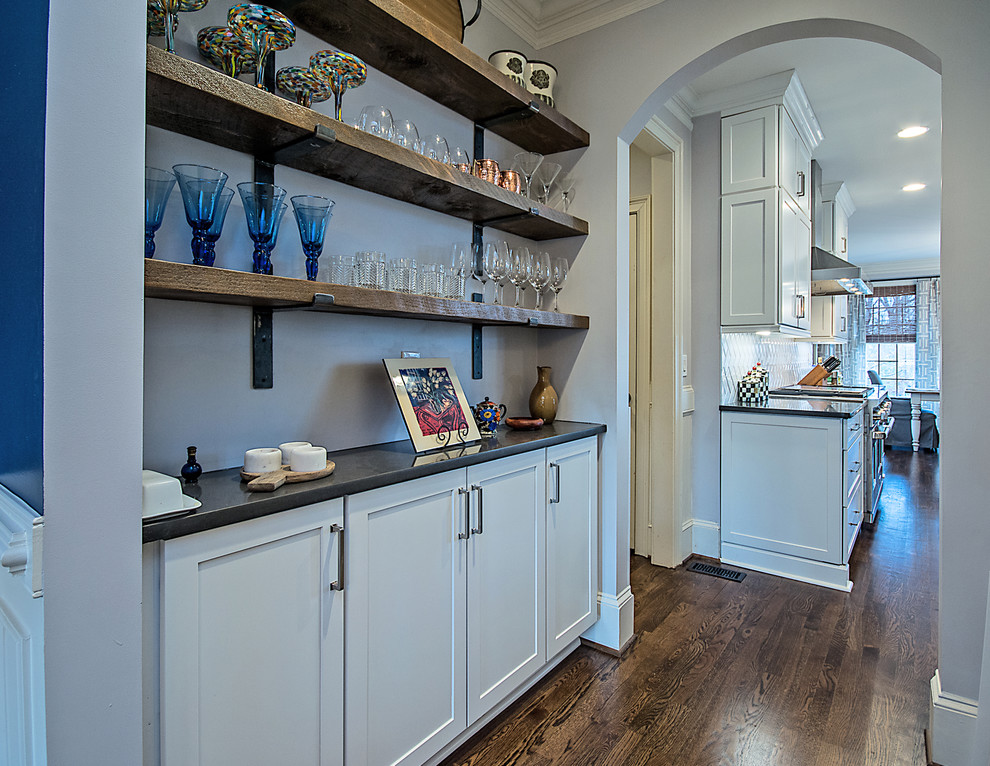 Example of a large transitional l-shaped medium tone wood floor and brown floor open concept kitchen design in Atlanta with a farmhouse sink, shaker cabinets, white cabinets, quartzite countertops, white backsplash, subway tile backsplash, stainless steel appliances and an island