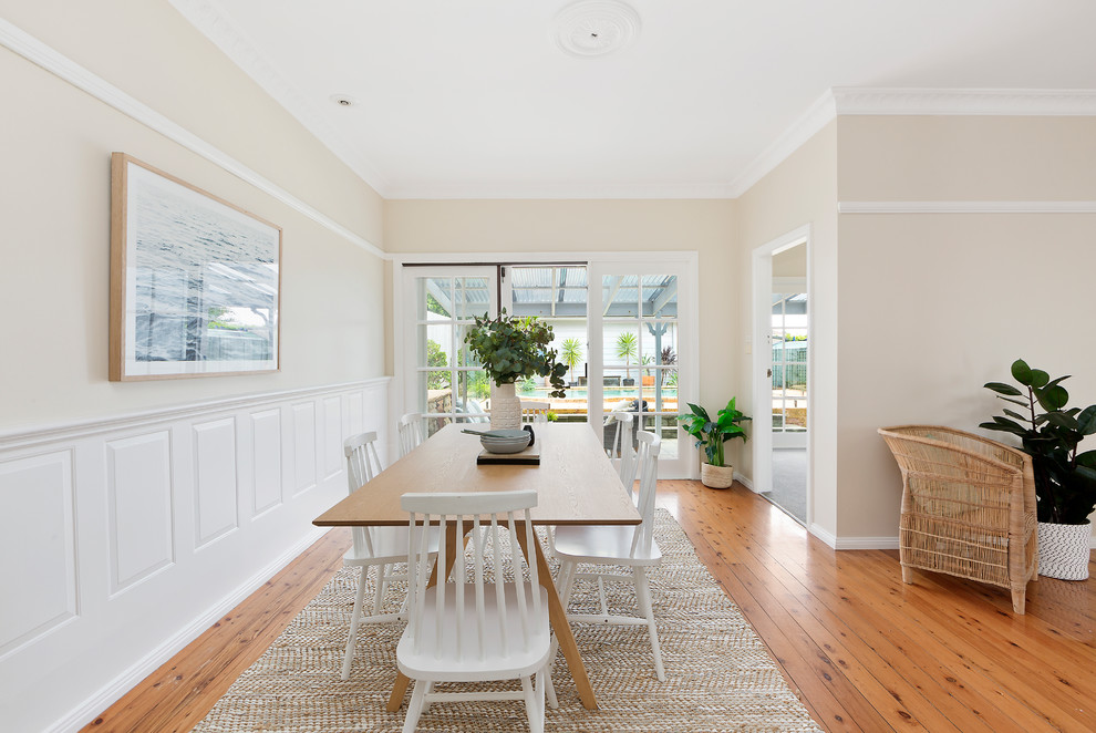 Transitional dining room in Sydney with light hardwood floors, brown floor, beige walls and no fireplace.