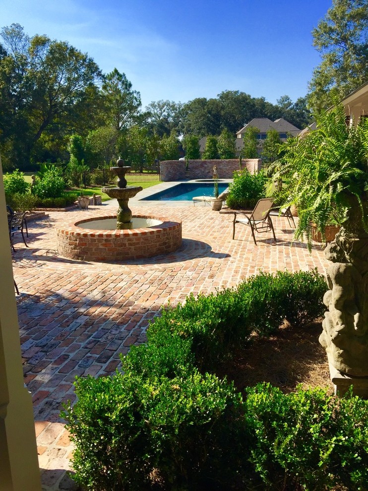 Large transitional backyard brick and custom-shaped lap pool fountain photo