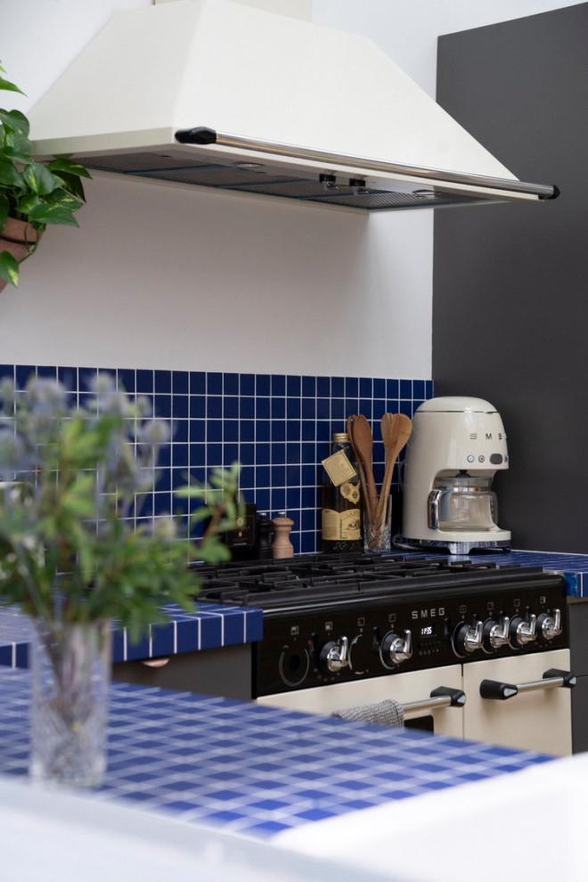 Foto di una grande cucina minimalista con lavello sottopiano, ante beige, paraspruzzi blu, paraspruzzi con piastrelle in ceramica, parquet chiaro, 2 o più isole, pavimento marrone e top blu