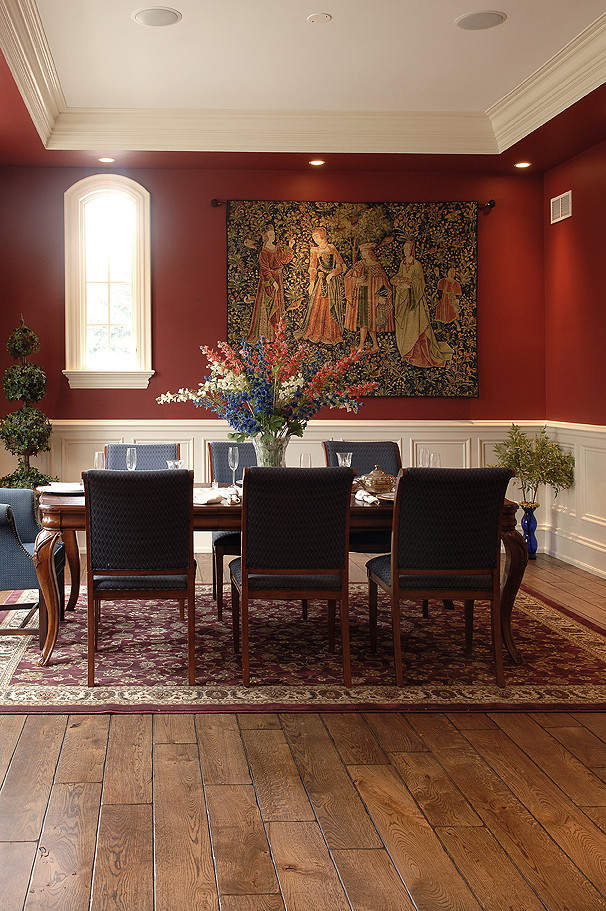 Example of a large french country medium tone wood floor, brown floor and tray ceiling dining room design in Chicago with red walls
