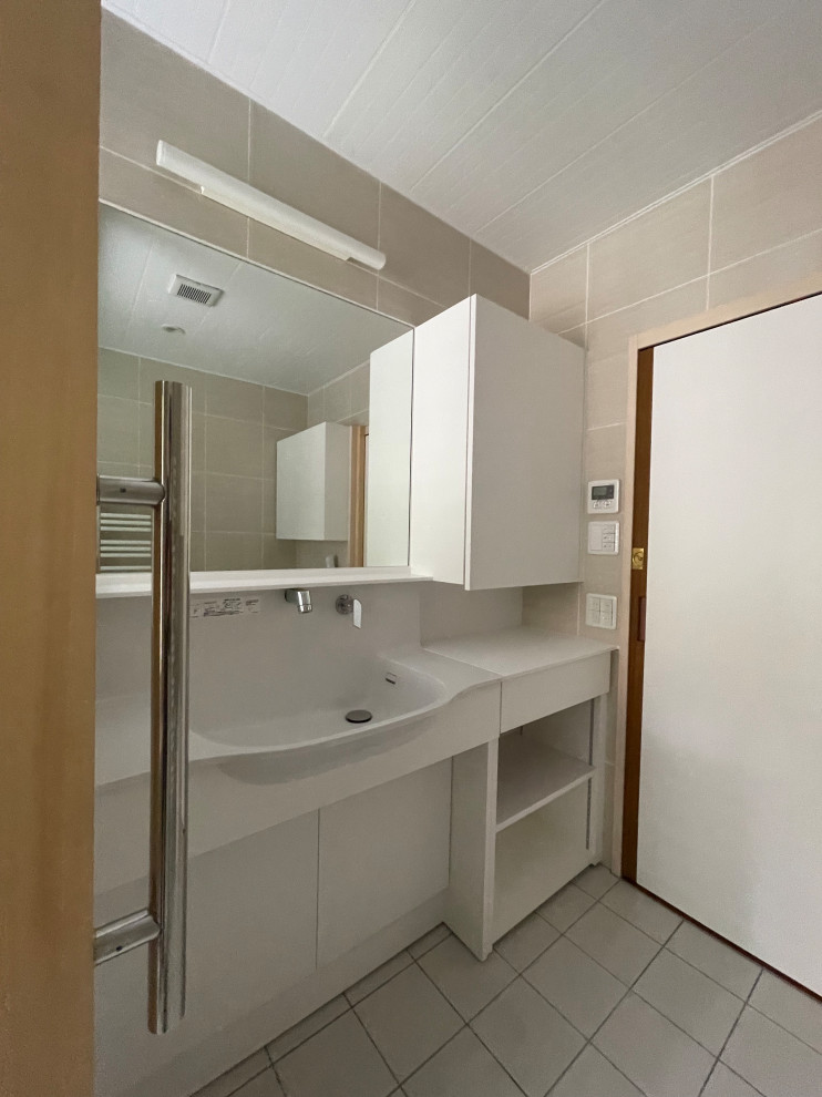 Photo of a mid-sized modern powder room in Tokyo with open cabinets, white cabinets, a one-piece toilet, beige tile, ceramic tile, beige walls, porcelain floors, an integrated sink, solid surface benchtops, white floor, white benchtops and a built-in vanity.