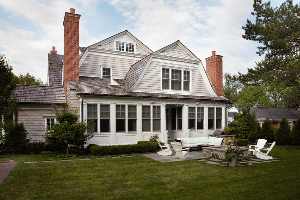 Inspiration for a large traditional two-storey beige house exterior in Chicago with mixed siding, a gambrel roof and a shingle roof.