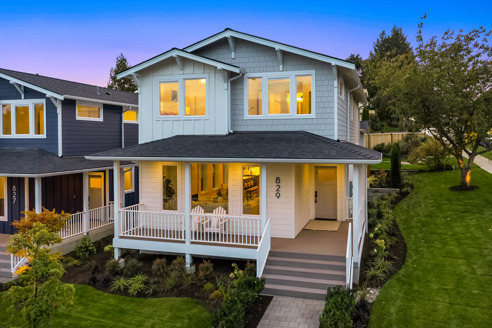 Inspiration for a mid-sized beach style two-storey white house exterior in Seattle with concrete fiberboard siding, a gable roof, a mixed roof, a black roof and board and batten siding.
