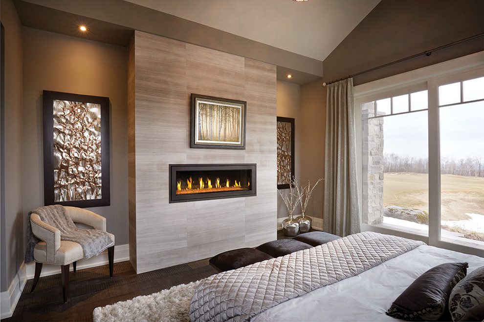 Example of a large minimalist master dark wood floor and brown floor bedroom design in Baltimore with beige walls, a ribbon fireplace and a tile fireplace