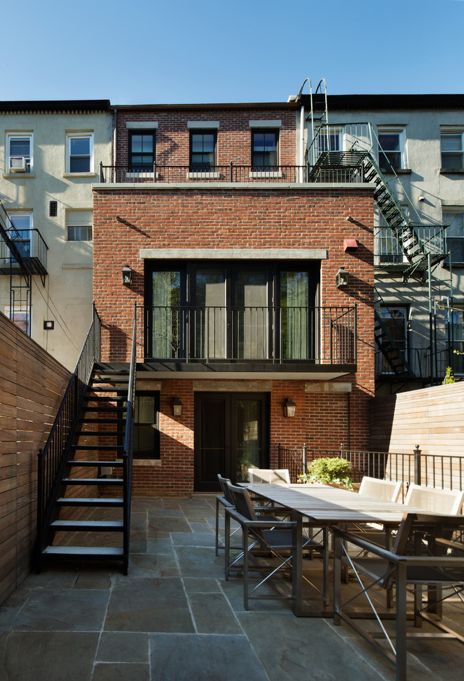 Inspiration for a traditional three-storey brick exterior in New York with a flat roof.