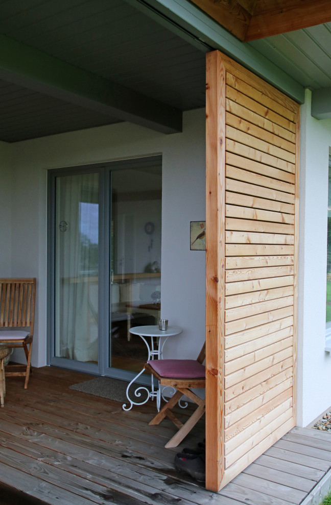 Mittelgroße, Überdachte Landhausstil Terrasse neben dem Haus mit Kübelpflanzen in Sonstige