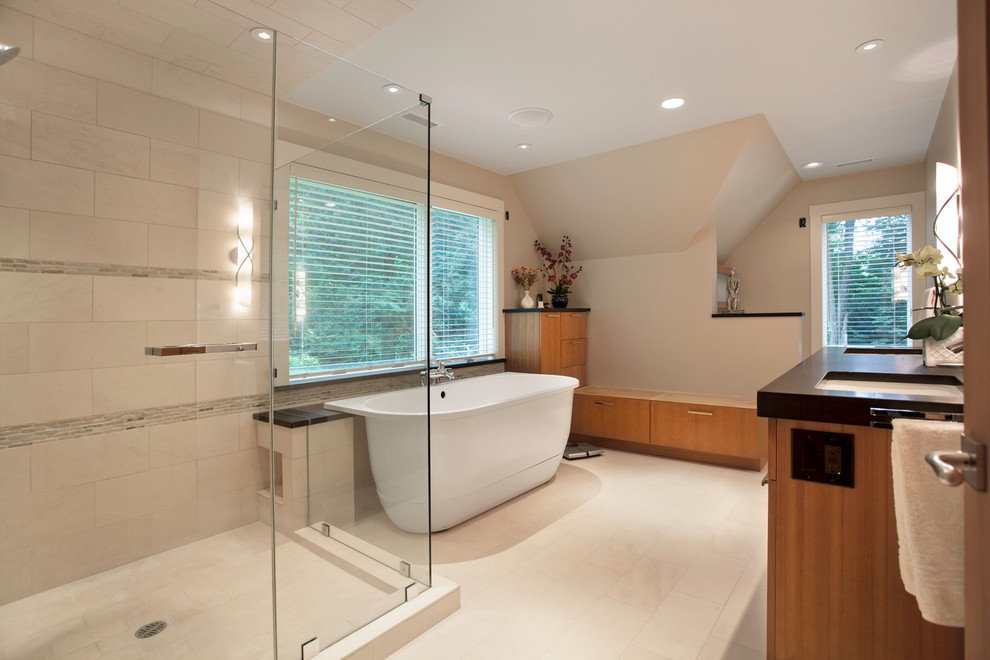 Design ideas for a mid-sized contemporary master bathroom in Boston with an undermount sink, flat-panel cabinets, medium wood cabinets, a freestanding tub, a corner shower, beige tile, porcelain tile, beige walls, porcelain floors and solid surface benchtops.