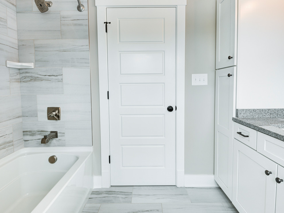 Aménagement d'une petite salle de bain principale craftsman avec un placard à porte shaker, des portes de placard blanches, parquet foncé, un plan de toilette en granite, meuble simple vasque et meuble-lavabo encastré.