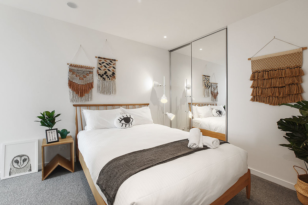 This is an example of a beach style bedroom in Melbourne with white walls, carpet and grey floor.
