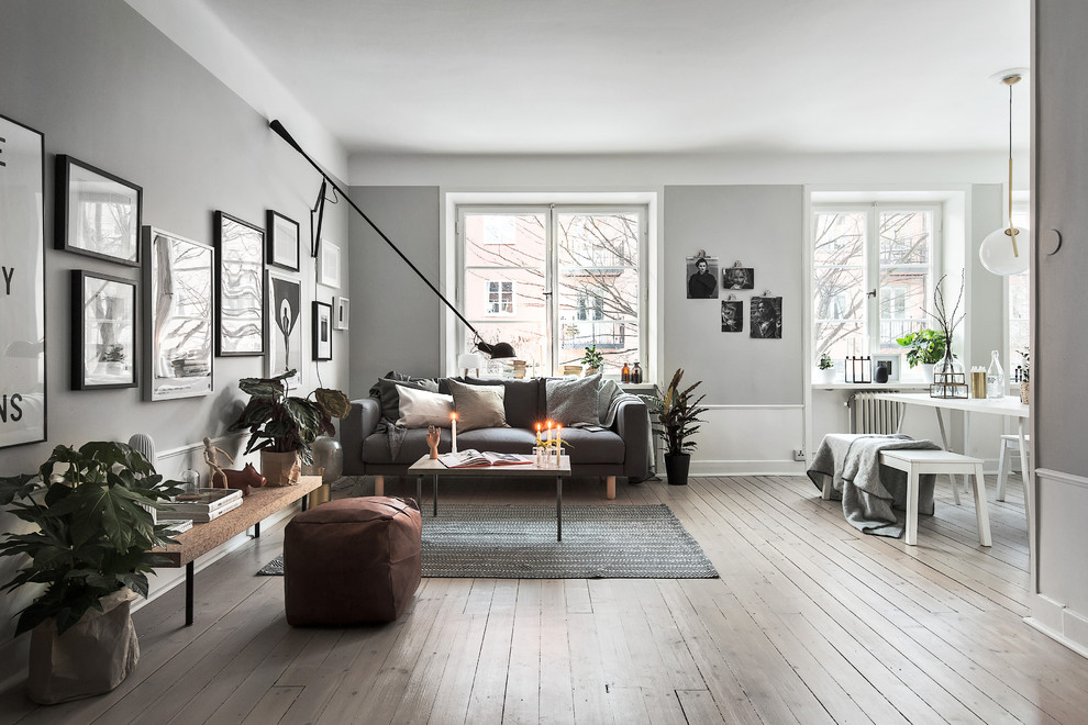 Inspiration for a scandinavian formal open concept living room in Stockholm with grey walls, light hardwood floors, no fireplace and no tv.