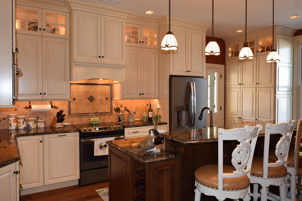 Example of a transitional medium tone wood floor kitchen design with a double-bowl sink, raised-panel cabinets, white cabinets, quartz countertops, beige backsplash, ceramic backsplash, stainless steel appliances and an island