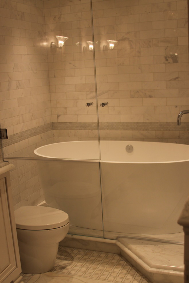 Example of a mid-sized transitional master multicolored tile and stone tile marble floor freestanding bathtub design in Atlanta with a vessel sink, beaded inset cabinets, beige cabinets, marble countertops, a one-piece toilet and gray walls