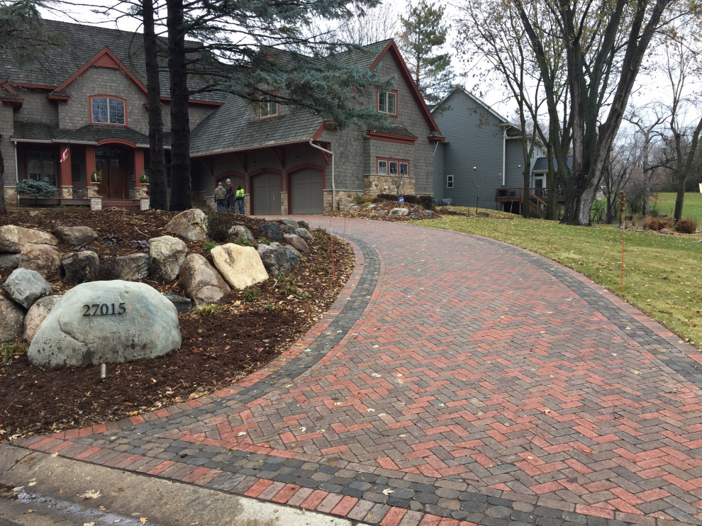 Inspiration for a large country front yard partial sun driveway for fall in Minneapolis with with path and brick pavers.