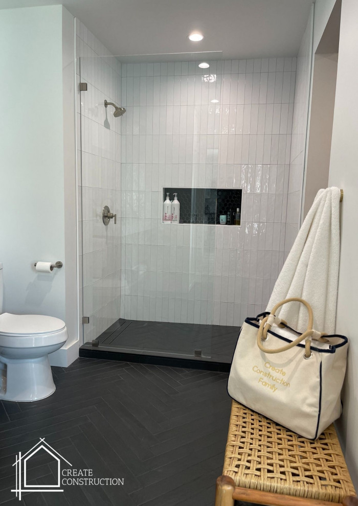 Пример оригинального дизайна: главная ванная комната среднего размера в стиле модернизм с плоскими фасадами, светлыми деревянными фасадами, открытым душем, унитазом-моноблоком, белой плиткой, плиткой кабанчик, белыми стенами, полом из плитки под дерево, врезной раковиной, столешницей из искусственного кварца, черным полом, открытым душем, белой столешницей, нишей, тумбой под одну раковину и напольной тумбой