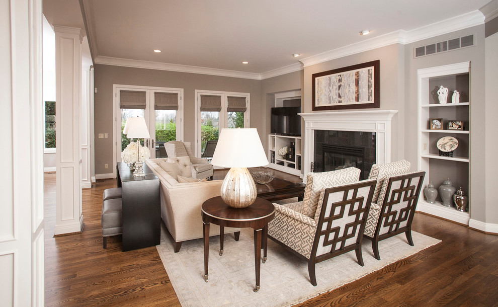 Large transitional open concept living room in Cincinnati with grey walls, dark hardwood floors, a standard fireplace and a built-in media wall.