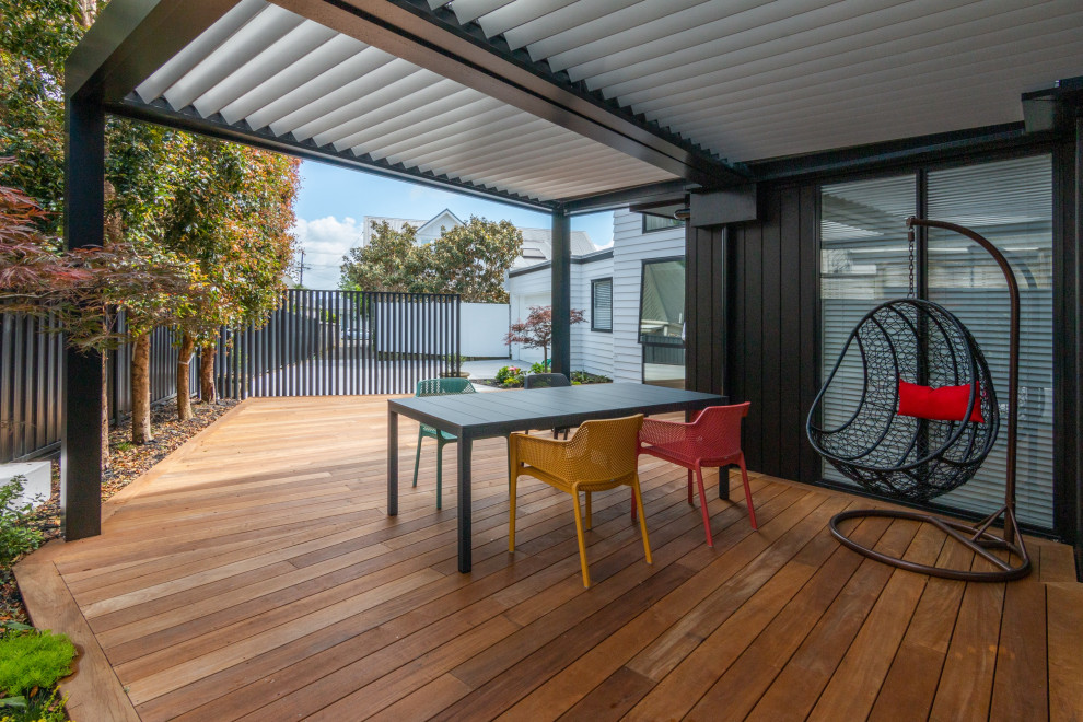 Diseño de terraza contemporánea de tamaño medio en patio lateral con pérgola y barandilla de metal