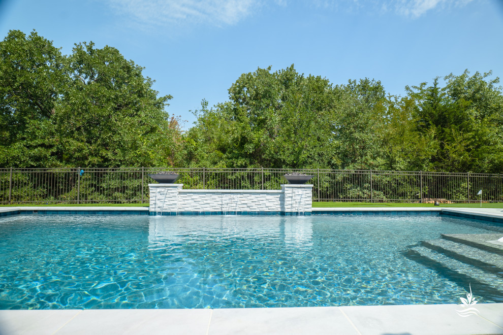 Idée de décoration pour un grand piscine avec aménagement paysager arrière minimaliste rectangle avec une terrasse en bois.