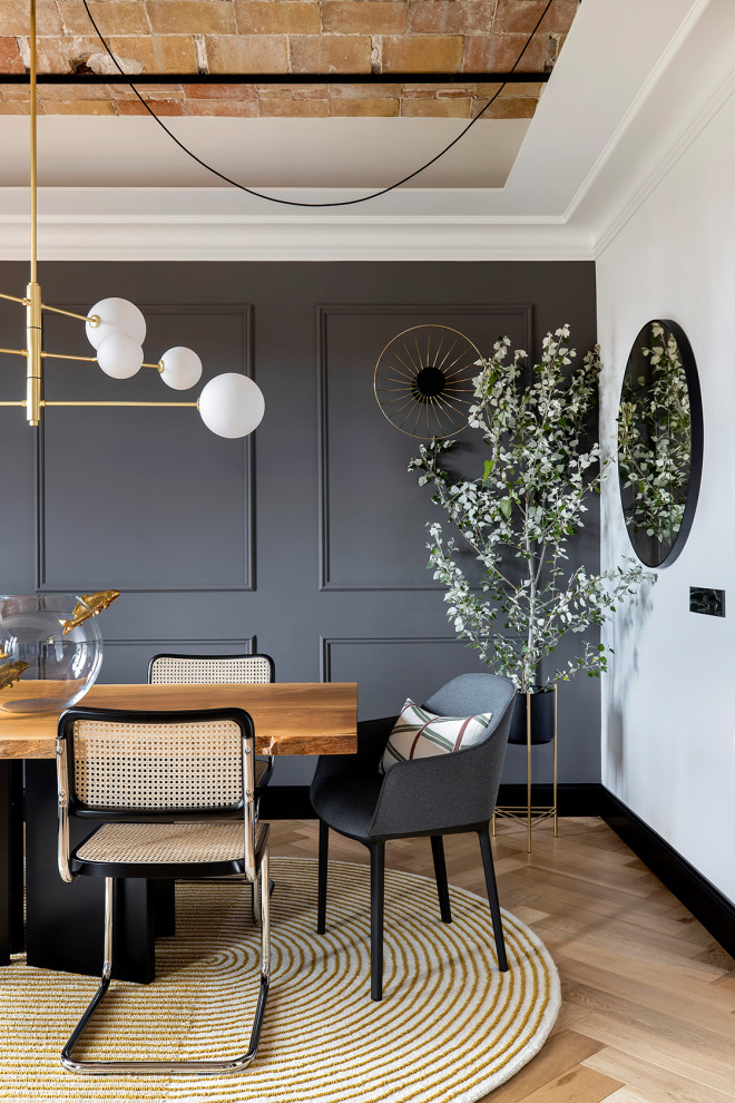 This is an example of a mid-sized transitional open plan dining in Barcelona with grey walls, medium hardwood floors, vaulted and decorative wall panelling.
