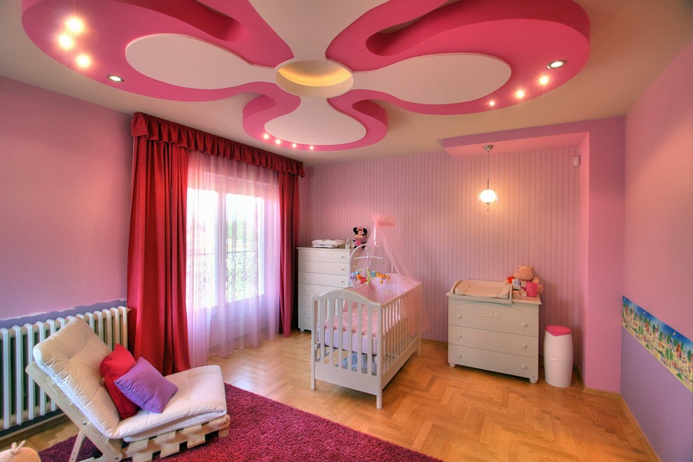 Inspiration for an eclectic nursery for girls in Other with pink walls and medium hardwood floors.