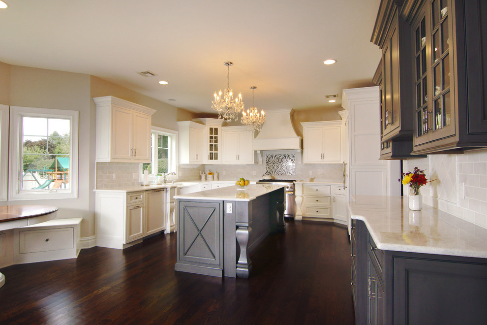 Eat-in kitchen - large transitional u-shaped dark wood floor eat-in kitchen idea in New York with white cabinets, white backsplash, an island, a farmhouse sink, beaded inset cabinets, subway tile backsplash and paneled appliances