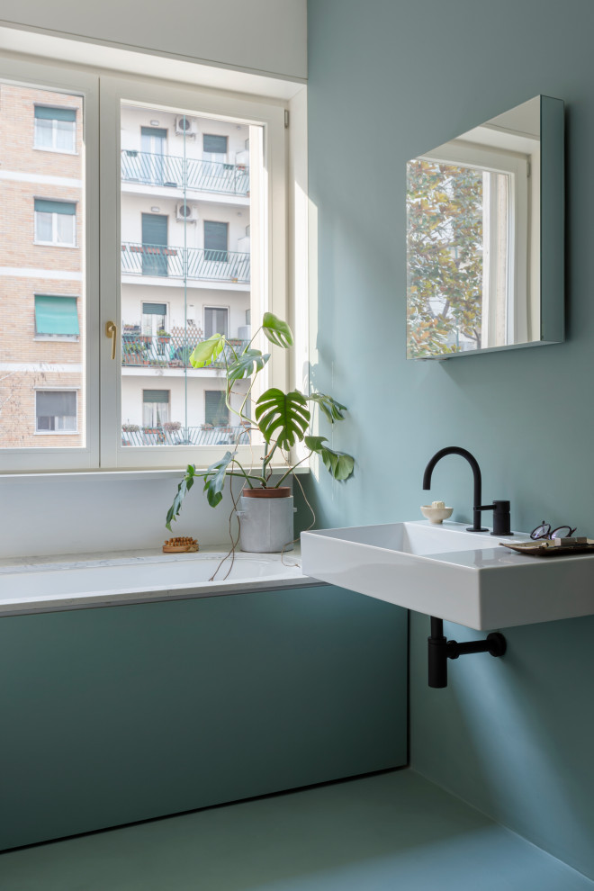 Стильный дизайн: ванная комната среднего размера в современном стиле с полновстраиваемой ванной, душем без бортиков, инсталляцией, зеленой плиткой, зелеными стенами, бетонным полом, душевой кабиной, столешницей из искусственного кварца, зеленым полом, душем с распашными дверями, белой столешницей и тумбой под одну раковину - последний тренд