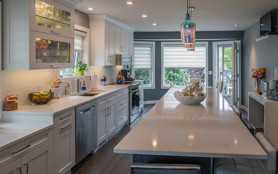 Kitchen - mid-sized transitional galley vinyl floor and brown floor kitchen idea in Calgary with an undermount sink, shaker cabinets, white cabinets, quartz countertops, white backsplash, porcelain backsplash, stainless steel appliances, an island and white countertops