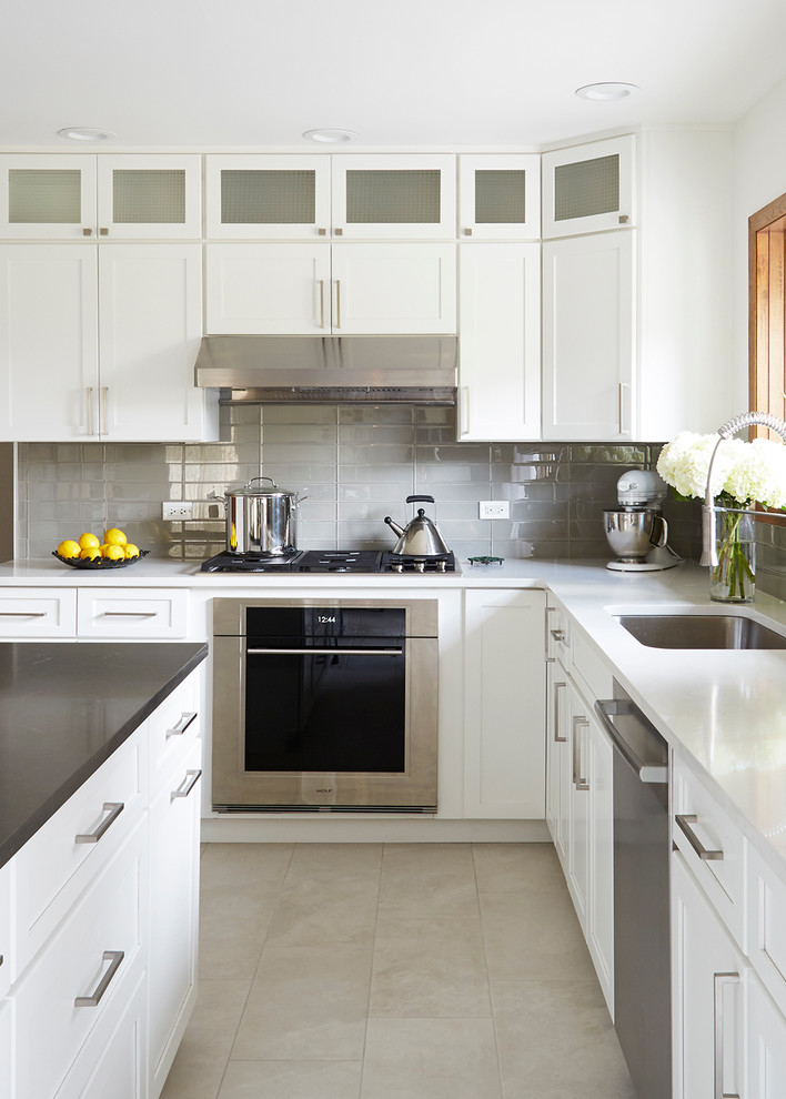 Eat-in kitchen - large contemporary galley porcelain tile eat-in kitchen idea in Chicago with an undermount sink, recessed-panel cabinets, white cabinets, quartz countertops, gray backsplash, glass tile backsplash, stainless steel appliances and an island