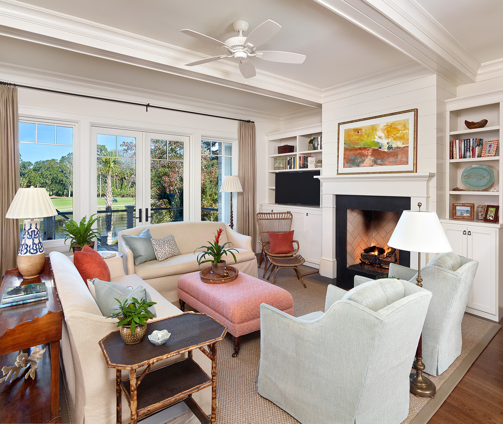 This is an example of a traditional formal living room in Charleston with white walls, medium hardwood floors, a standard fireplace and a freestanding tv.