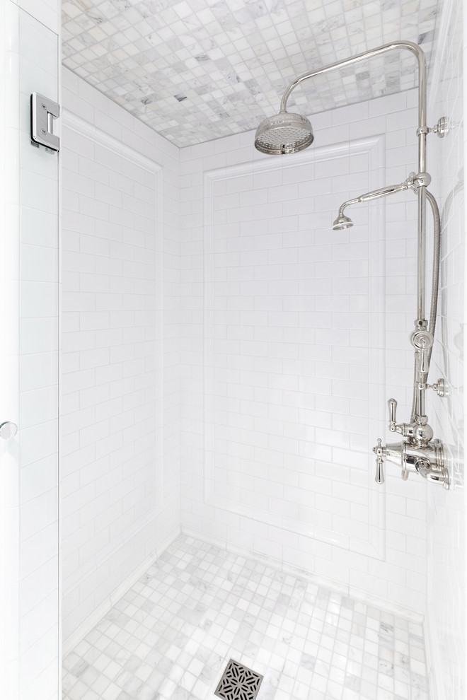 This is an example of a small modern 3/4 bathroom in San Diego with open cabinets, blue cabinets, an alcove shower, white tile, ceramic tile, marble floors, an integrated sink, marble benchtops, black floor, a hinged shower door and white benchtops.