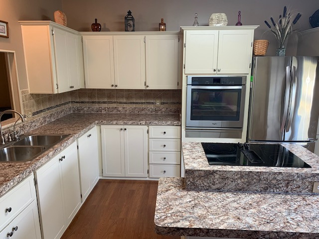 Example of a large l-shaped eat-in kitchen design with shaker cabinets, beige cabinets, laminate countertops, an island and brown countertops