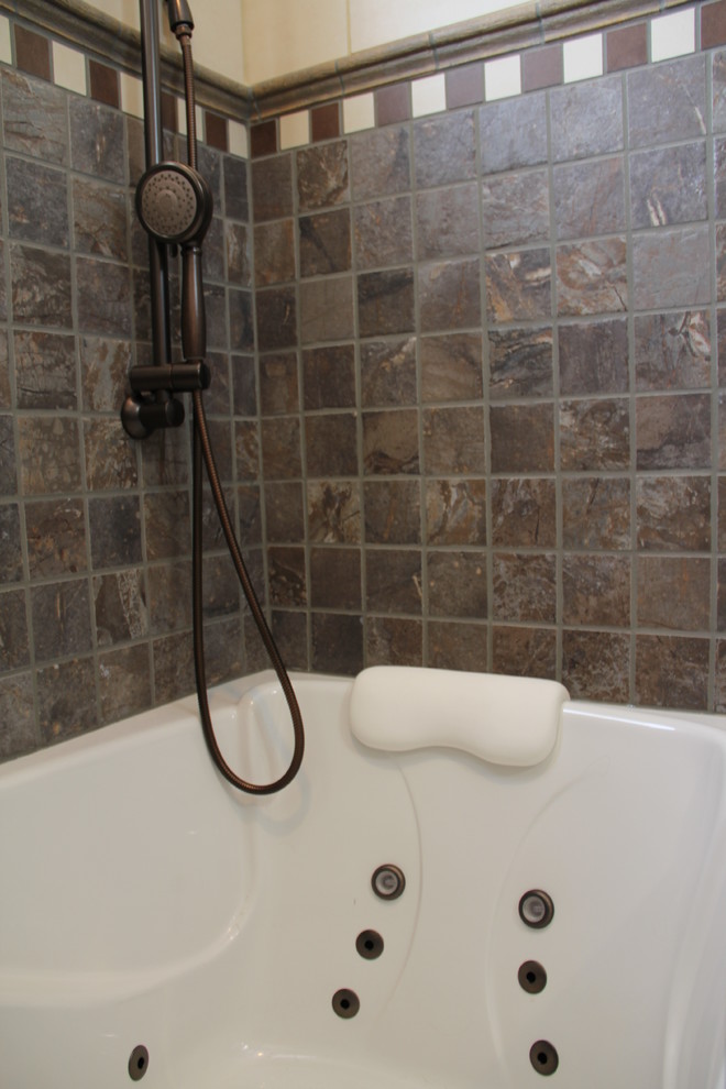 Transitional brown tile and porcelain tile porcelain tile tub/shower combo photo in Columbus with a vessel sink, an undermount tub, a two-piece toilet, raised-panel cabinets, medium tone wood cabinets, granite countertops and beige walls