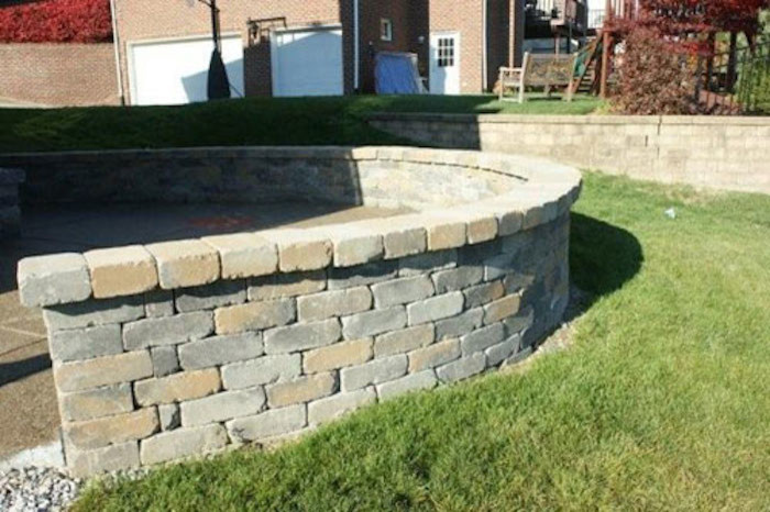 Photo of a mid-sized full sun backyard retaining wall landscape.
