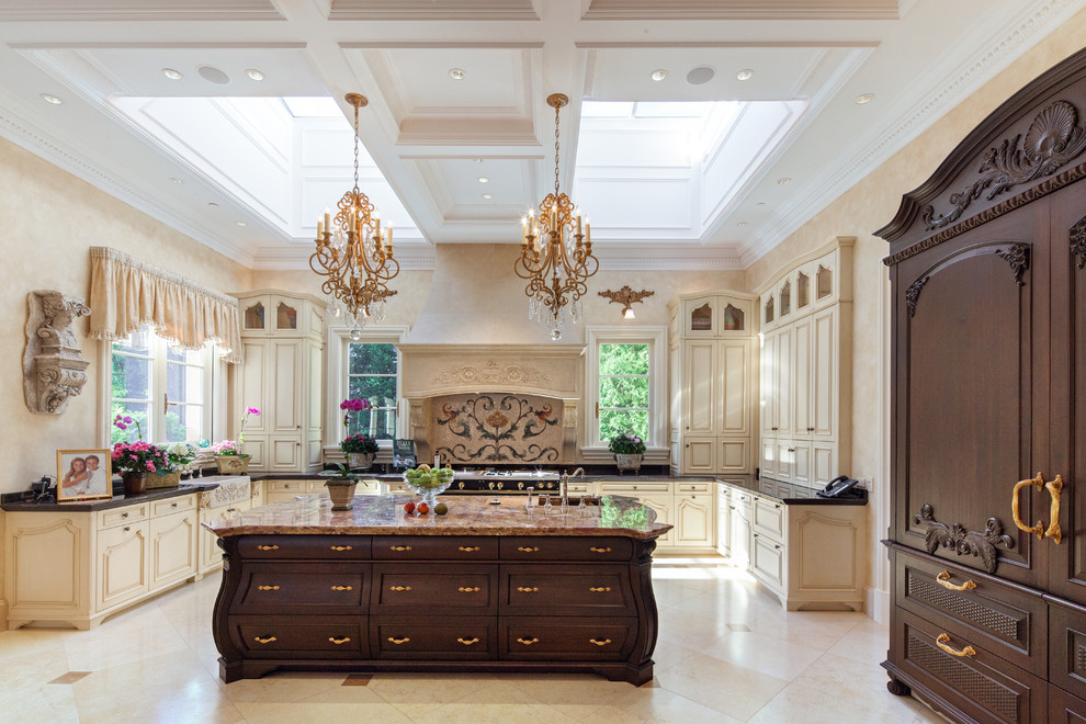 This is an example of an expansive mediterranean u-shaped eat-in kitchen in Chicago with panelled appliances, with island, a farmhouse sink, raised-panel cabinets, light wood cabinets, onyx benchtops, multi-coloured splashback and travertine floors.