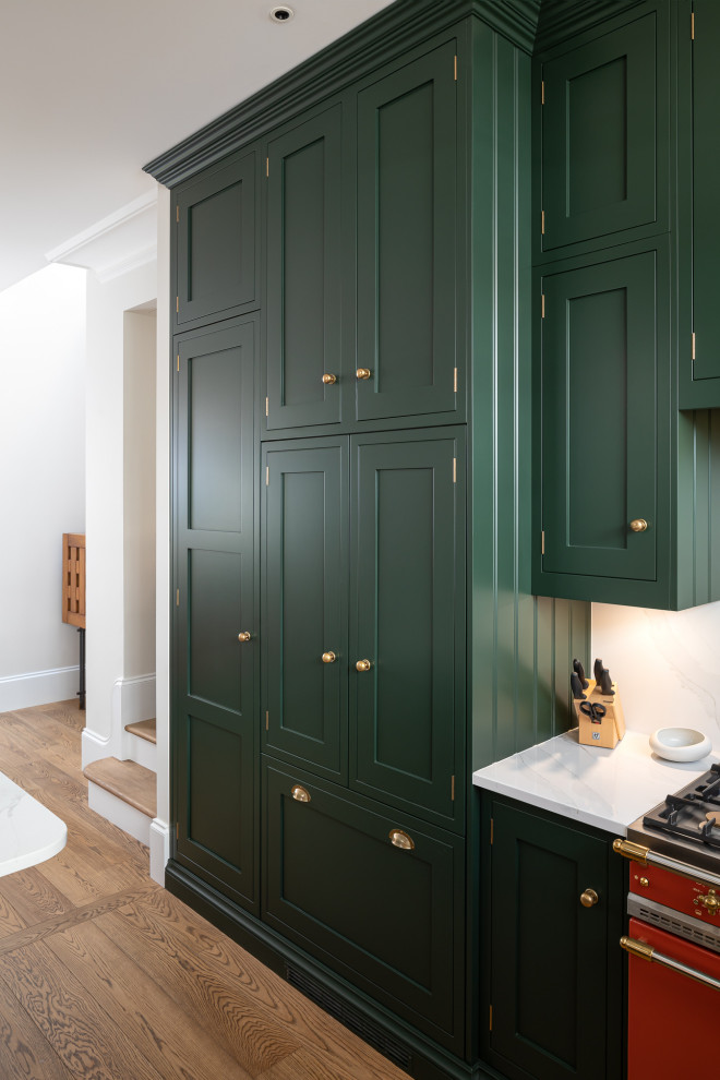This is an example of a small eclectic u-shaped kitchen in London with shaker cabinets, green cabinets, quartzite benchtops, white splashback and white benchtop.