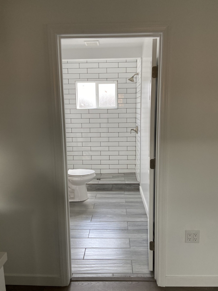 Mid-sized traditional master bathroom in Los Angeles with flat-panel cabinets, white cabinets, an open shower, a two-piece toilet, white tile, subway tile, white walls, ceramic floors, an undermount sink, quartzite benchtops, grey floor, a sliding shower screen, white benchtops, a single vanity, a floating vanity and recessed.