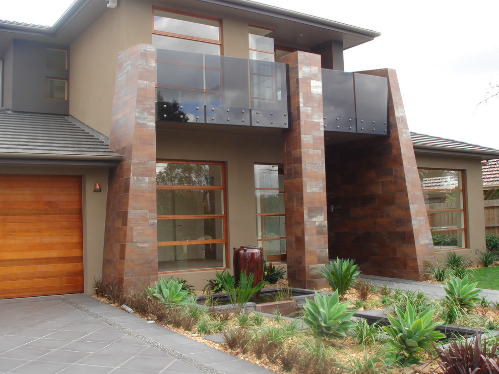 This is an example of a large contemporary two-storey stucco brown exterior in Melbourne.