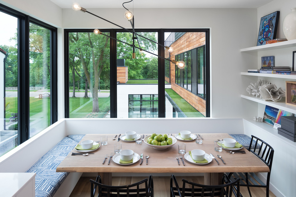 Photo of a contemporary dining room in Minneapolis with white walls, light hardwood floors and no fireplace.